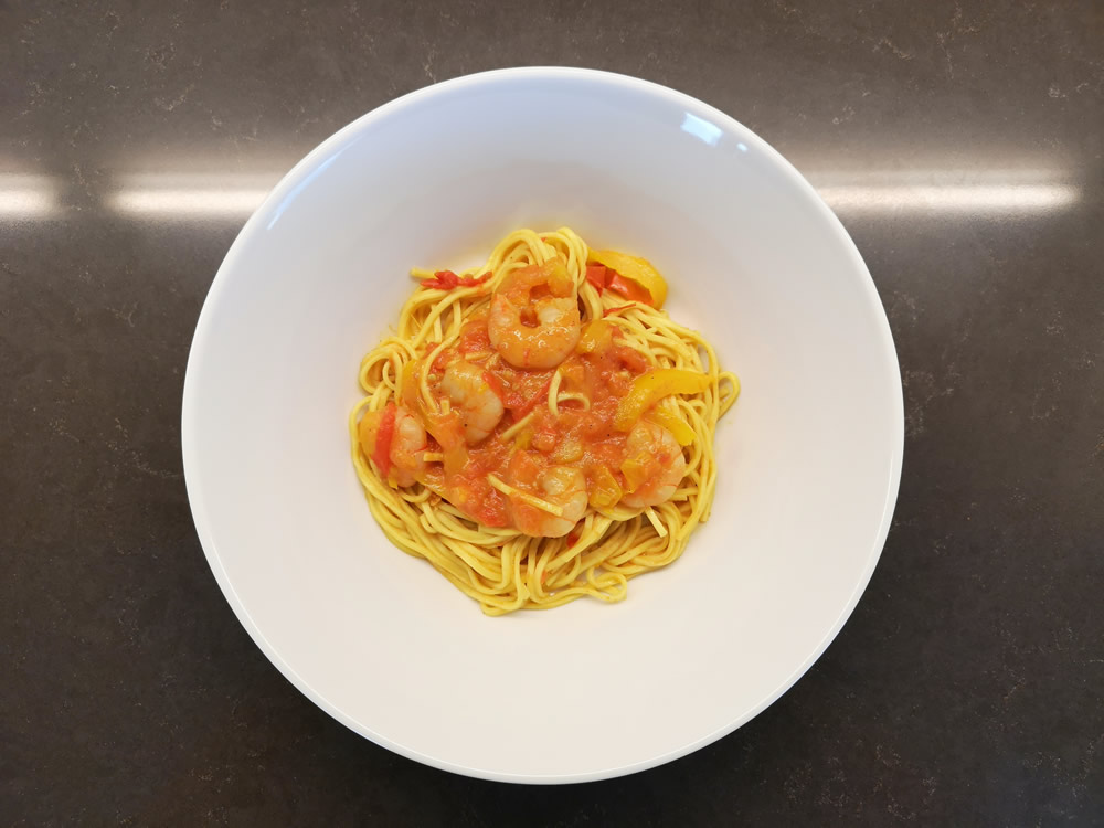 Tagliolini an Tomaten-Curry Sauce mit Peperoni und Crevetten